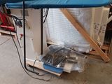 une planche à repasser bleue posée sur un support dans un garage