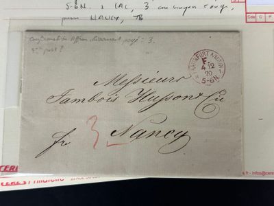 une vieille enveloppe sur laquelle figure une lettre manuscrite, posée sur une table