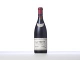 a bottle of red wine sitting on top of a white table
