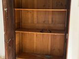 an old wooden cabinet with a door open on a hard wood floor