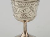 a silver goblet with a bird design on the rim