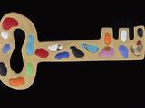 a gold key shaped like a keyhole with colorful stones on it