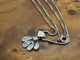 collier plaqué argent avec un pendentif en forme de libellule monté sur un support en bois