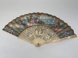 a fan with a painting on it sitting on top of a table
