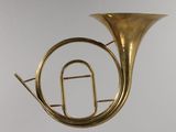 a brass french horn hanging from the ceiling