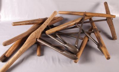 une pile de battes de baseball en bois posées sur une surface blanche