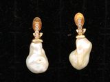 une paire de boucles d'oreilles en perles et diamants sur fond de velours noir