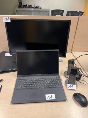 un ordinateur portable posé sur un bureau à côté d'un moniteur