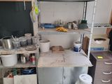 a small kitchen with many pots and pans on the counter