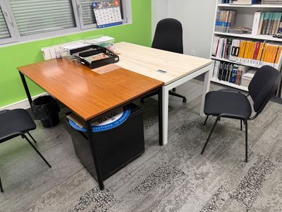 des tables et des chaises dans une pièce où se trouvent des bibliothèques et encore des bibliothèques
