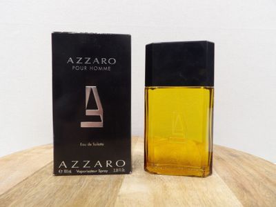 un gros plan sur un flacon de parfum posé sur une table en bois