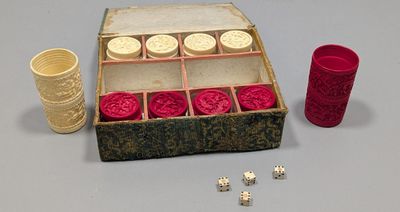 a box of dice and a cup next to it on a table