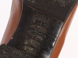 the bottom of a pair of black shoes with brown soles