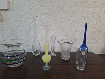 de nombreux vases en verre posés sur une table en bois