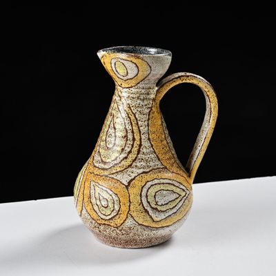 un vase jaune et blanc posé sur une table blanche