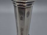a close up of a silver vase sitting on a table
