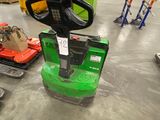 a green forklift sitting in a warehouse with other forklifts in the background