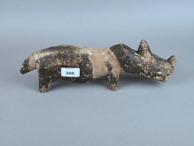 une photo d'une figurine représentant un cochon, sur laquelle est accrochée une étiquette
