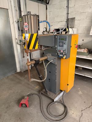 a machine that is sitting in a garage with a hose