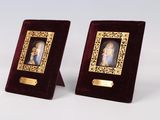 une paire de cadres photo anciens ornés de dorures et contenant chacun la photo d'une femme en robe