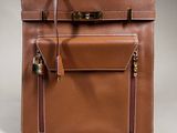a brown leather bag with a lock on the front of it