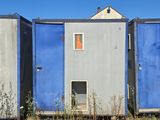 three portable toilets sitting in a field next to each other