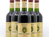 six bouteilles de vin sont alignées sur une surface blanche