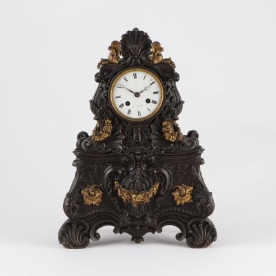 a black and gold clock sitting on a white surface
