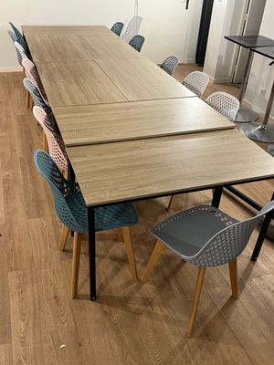 des tables et des chaises dans une pièce avec un parquet et des murs blancs