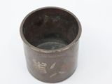 a metal cup with writing on it on a white surface