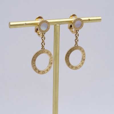 une paire de boucles d'oreilles en or ornées de pierres blanches, montées sur une tige en or