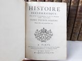 a book that is open on a table in front of a bunch of books