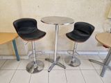 trois chaises et une table dans le coin d'une pièce