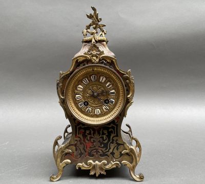 une horloge posée sur un socle, sur une surface grise