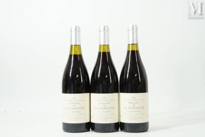 trois bouteilles de vin sont posées sur une surface blanche