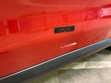 a close up of a red car with a sticker on it