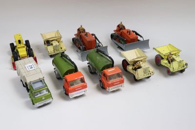 six camions miniatures alignés sur une surface blanche