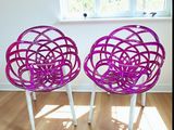 une paire de chaises en osier violet posées sur un parquet en bois massif