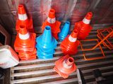 many orange and blue cones sitting in the back of a truck