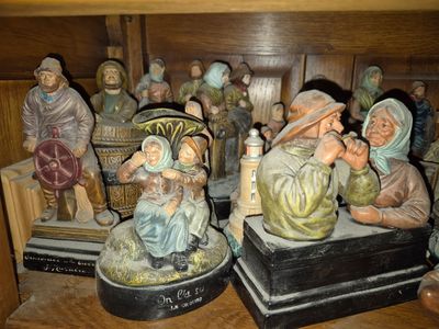 many figurines of people sitting on a shelf