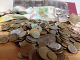 a pile of coins sitting on a table next to a pile of money