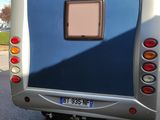 a silver and blue bus that is parked on the side of the road
