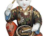 une figurine représentant un homme tenant un tambour à la main
