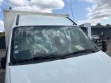 a white van parked in a parking lot with clouds in the background