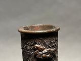 a silver vase with a design on it sitting on a table