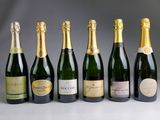 six bottles of champagne lined up in a row on a table