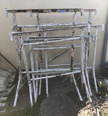 a pile of old metal frames sitting outside of a building