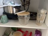 a white cabinet with a sink and pots and pans in it