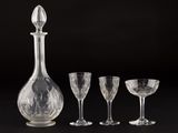 three wine glasses and a decanter on a table