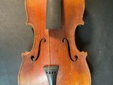 an old violin hanging on a wall with a black background